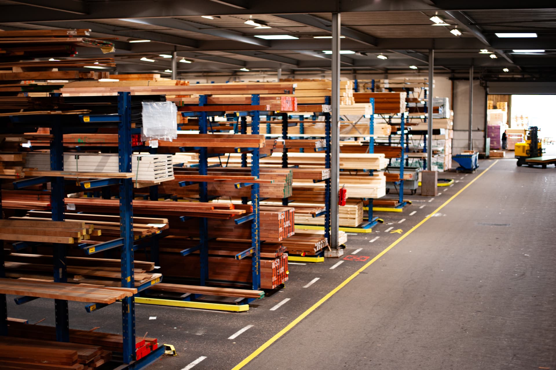 Stellingen vol hout en plaatmateriaal in het magazijn van Miedema