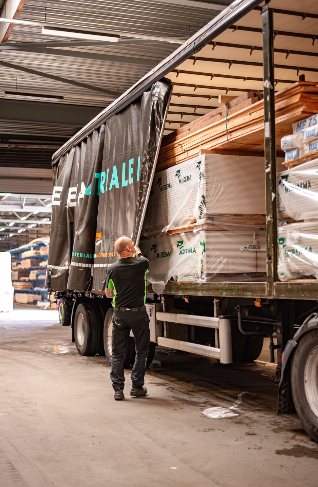 Medewerker laadt een Miedema-vrachtwagen met bouwmaterialen